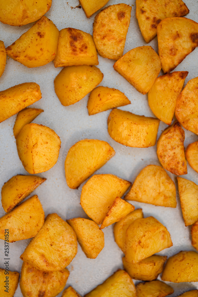Close up of baking tray with Patatas Bravas, a traditional Spanish tapas dish, potato cubes or wedges roasted, baked or deep fried until tender and cripsy on the outside Close up of baking tray with Patatas Bravas, a traditional Spanish tapas dish, potato cubes or wedges roasted, baked or deep fried until tender and cripsy on the outside