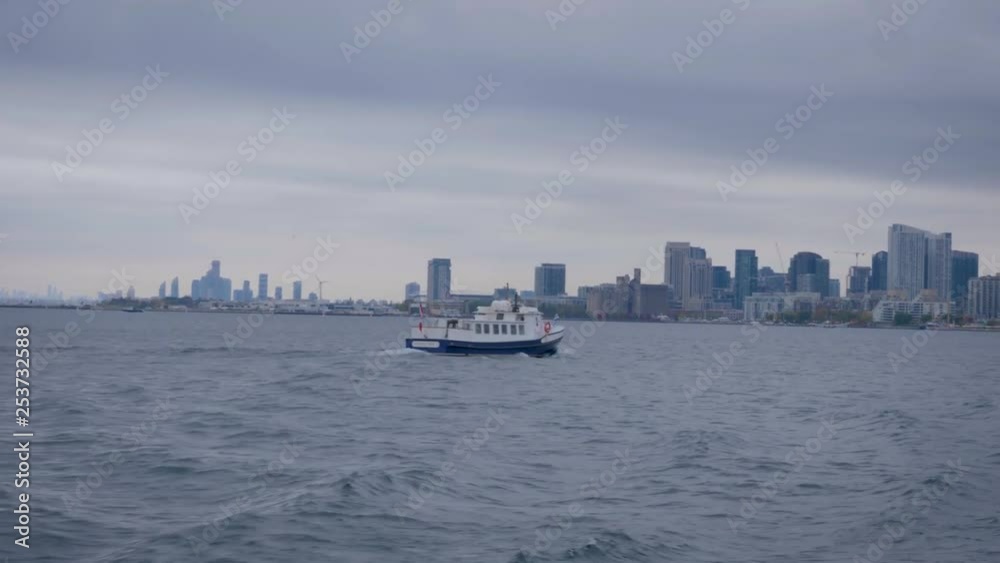A small Ferry speedily drives toward Toronto on Ontario Lake. A small Ferry speedily drives toward Toronto on Ontario Lake.