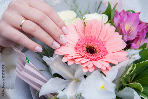 hand with a ring holds a bouquet of flowers