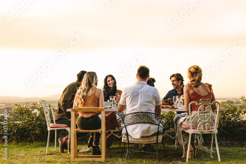 Group of young friends having dinner party photo