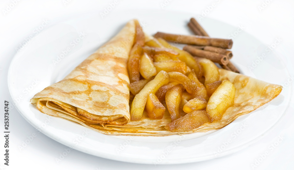 Thin delicious pancake with fired apple on white Thin delicious pancake with fired apple on white