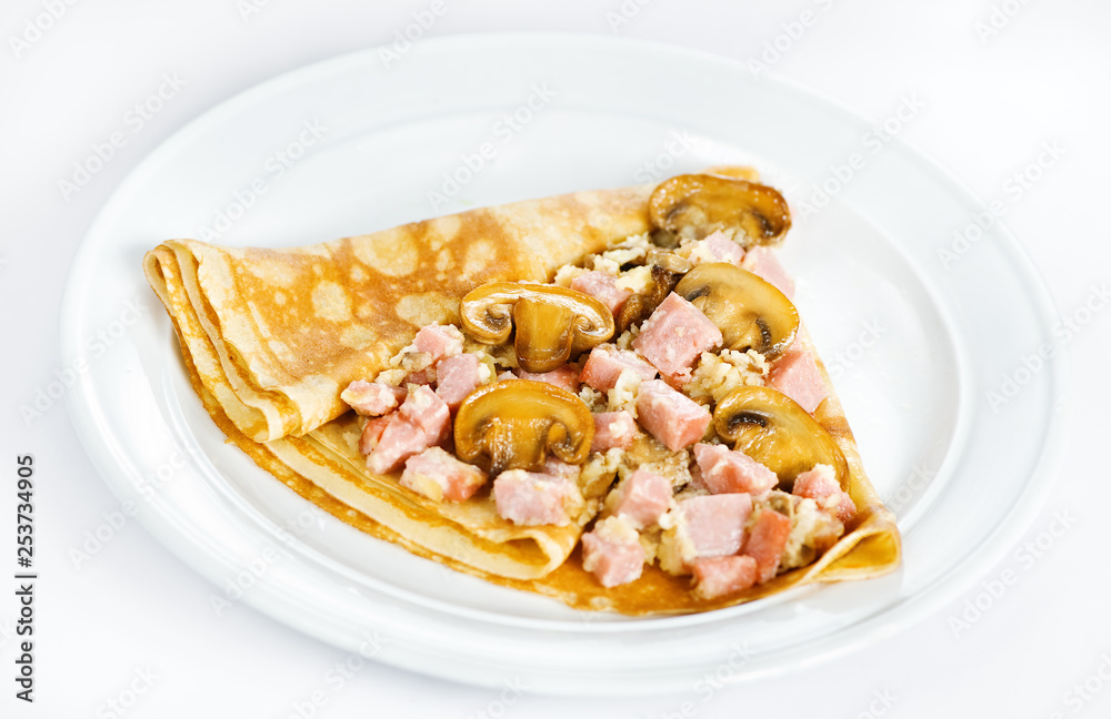 Thin delicious pancake with ham and mushrooms on white Thin delicious pancake with ham and mushrooms on white