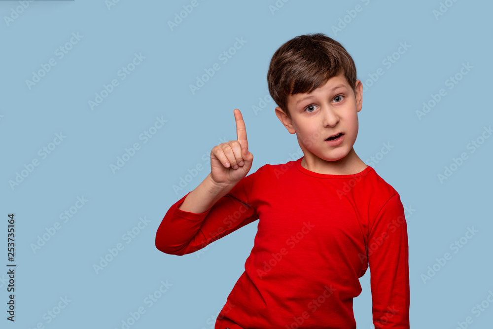 Studio shot of a boy proving something by raising his index finger up, isolate with copy space Studio shot of a boy proving something by raising his index finger up, isolate with copy space