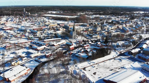 Drone footage flying over a small town approaching the church on a beautiful sunny winter day. A mining industrial building is visible the background. Filmed in realtime at 4k. photo