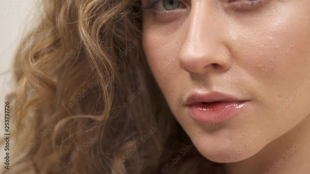 Bottom up shooting of a charming young woman with green eyes and natural curly hair Bottom up shooting of a charming young woman with green eyes and natural curly hair
