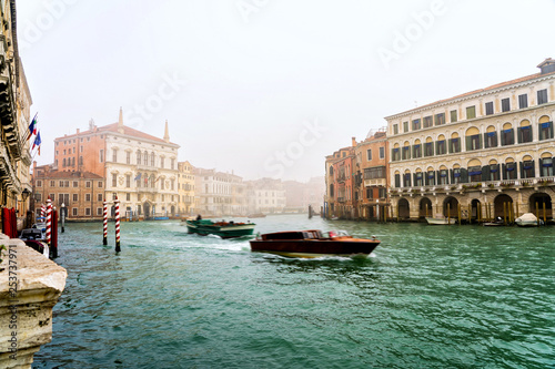 Typical bussy venetian street in misty spring day, Italy. Traditional venice canal in fog.