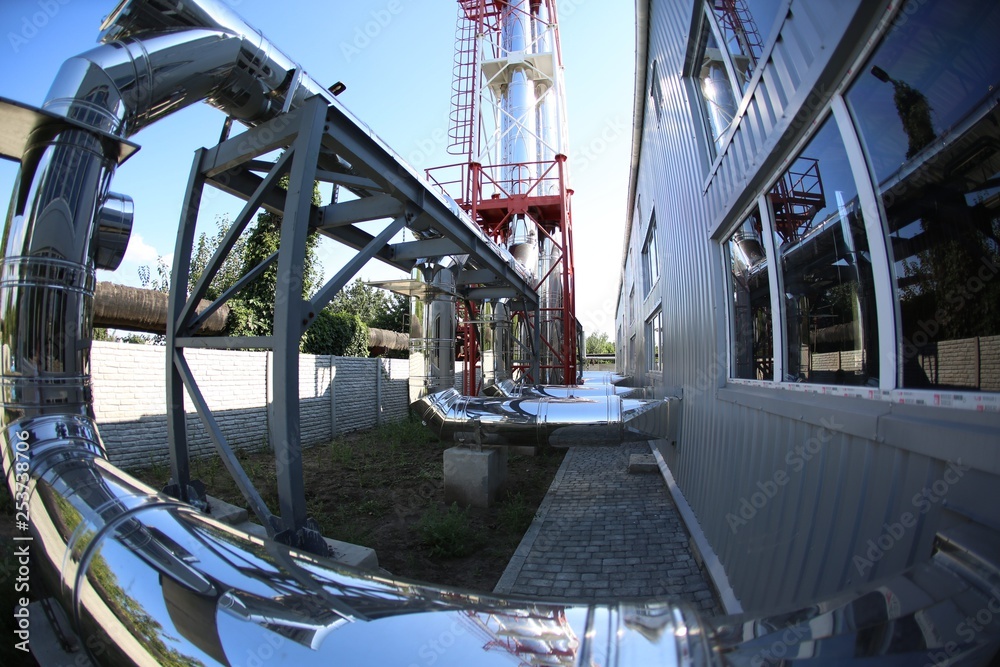 Wide-angle panoramic photo of the newest alternative fuel boiler room with pipes, towers and tanks, on a clear summer day, without people Wide-angle panoramic photo of the newest alternative fuel boiler room with pipes, towers and tanks, on a clear summer day, without people