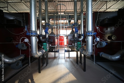 Wide-angle panoramic photo of the newest alternative fuel boiler room with pipes, towers and tanks, on a clear summer day, without people