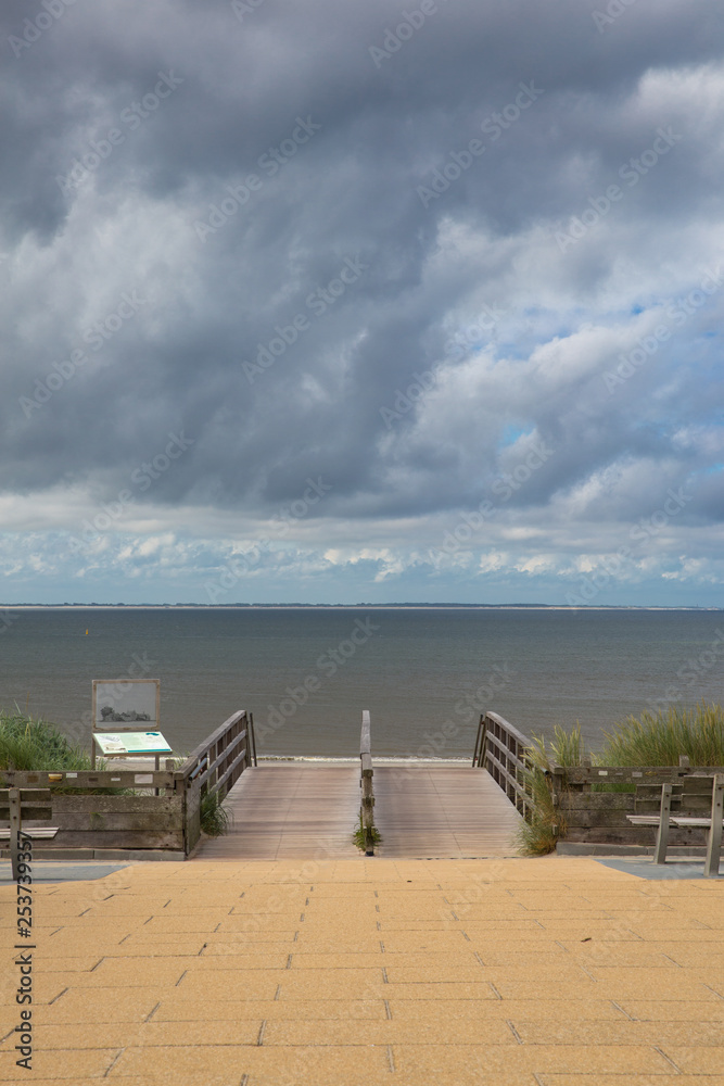 Obraz premium Weg zum Strand. Wolken und Sturm über dem Meer.