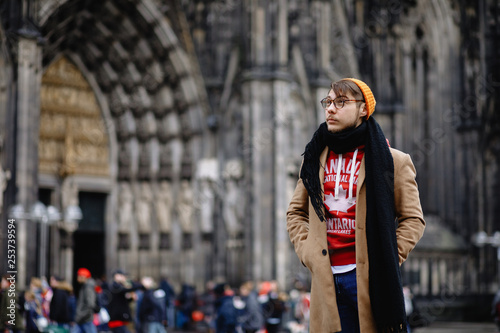Casual style. Man stands against the sights. Cathedral Church of Saint Peter. Cologne Cathedral. Germany. Gothic architecture. 