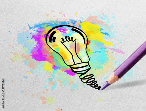 Drawing colorful bulb and multimedia symbols on white paper
