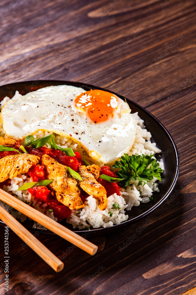 Grilled meat, white rice,fried egg vegetables on wooden table Grilled meat, white rice,fried egg vegetables on wooden table