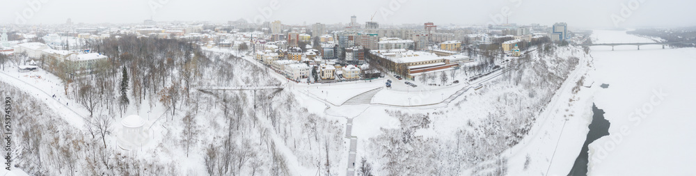 Obraz premium the city of Kirov and the high bank of the river Vyatka and the Alexander Grin Embankment and the rotunda on a cloudy winter day.