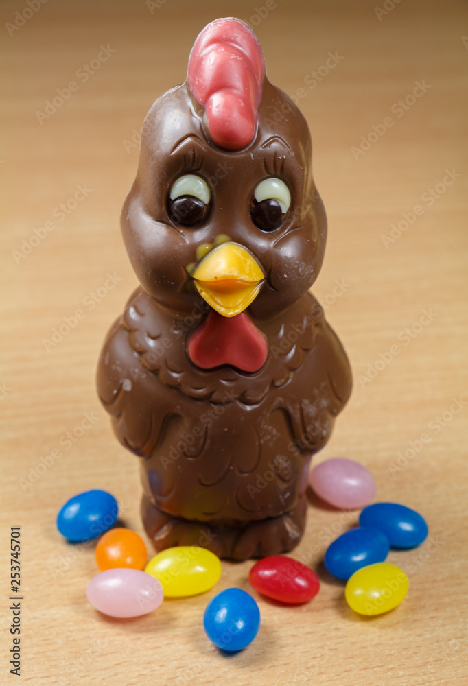 Milk chocolate hen and multicolored sugar candies for Easter
