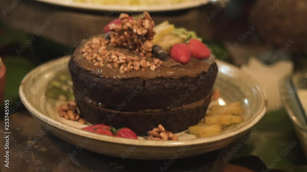 pan shot of a delicious vegan cake on a table under candlelight pan shot of a delicious vegan cake on a table under candlelight