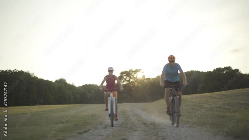 4k couple cycling in grassland on late summer afternoon 4k couple cycling in grassland on late summer afternoon