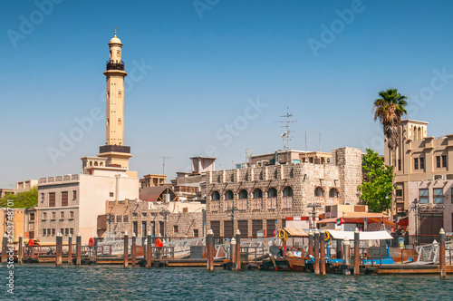 Skyline view of Dubai Creek with traditional boats and piers, United Arab Emirates.