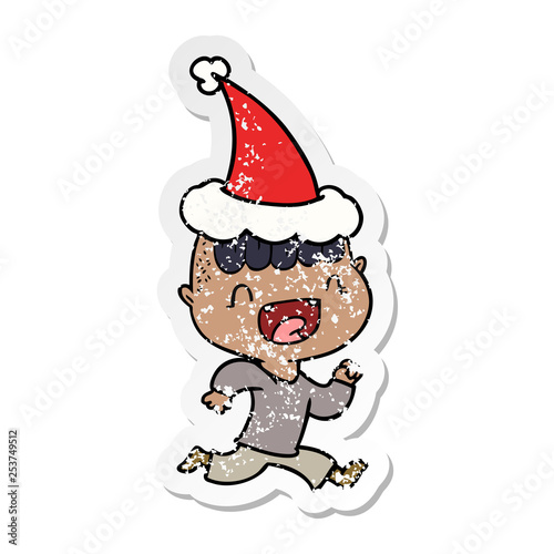 distressed sticker cartoon of a happy boy laughing and running away wearing santa hat © lineartestpilot