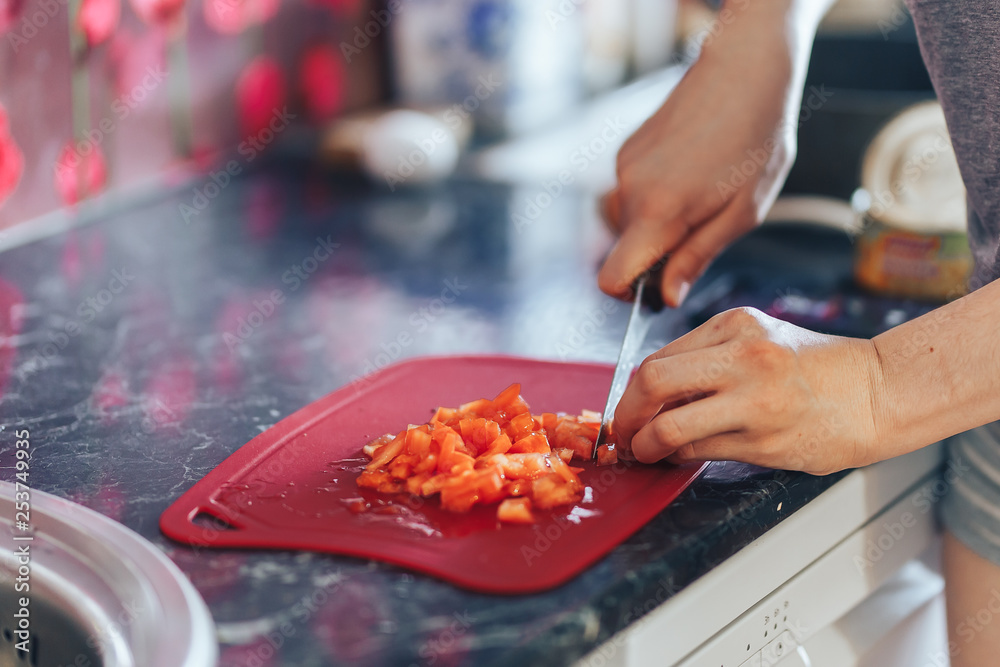 woman hands cutting vegetables. Cook hands cutting tomato cutting board