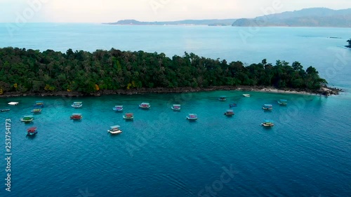 Aerial footage of Iboh area in Sumatra, Indonesia. Evening light and calm sea with boats cruising tropical island scenery. photo