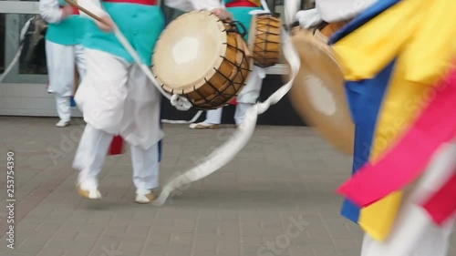 Korean national festival. A group of musicians and dancers in bright colored suits perform traditional Korean folk dance Samul nori Samullori or Pungmul and play percussion Korean musical instruments photo