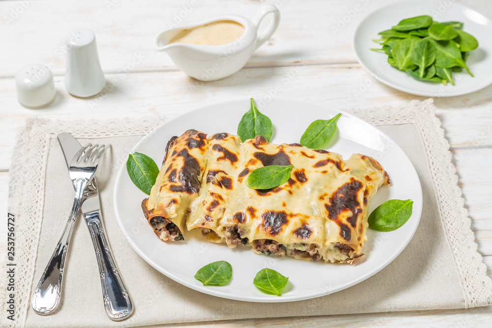 Cannelloni with minced beef and spinach baked in béchamel sauce. 