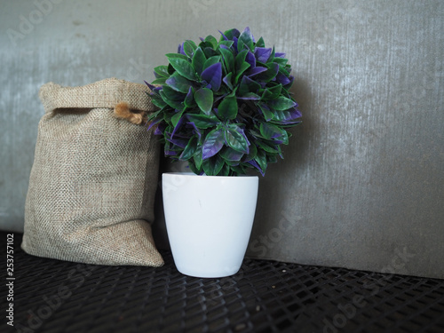 Close up of plant pots and cloth bags placed on black mesh with cement texture background.