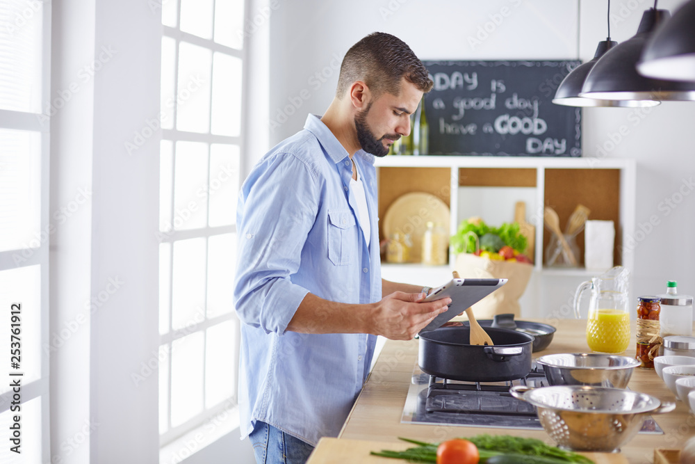 Smiling and confident chef standing in large kitchen Smiling and confident chef standing in large kitchen