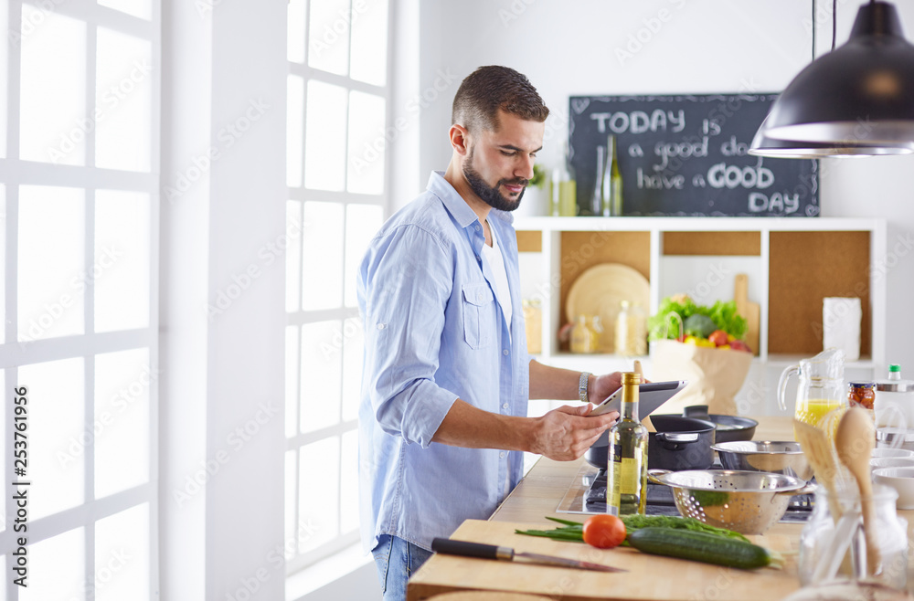 Smiling and confident chef standing in large kitchen Smiling and confident chef standing in large kitchen