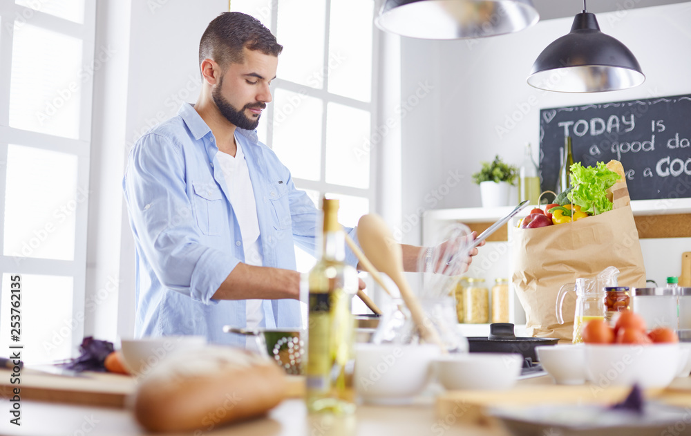 Smiling and confident chef standing in large kitchen