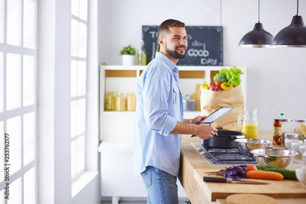 Smiling and confident chef standing in large kitchen Smiling and confident chef standing in large kitchen