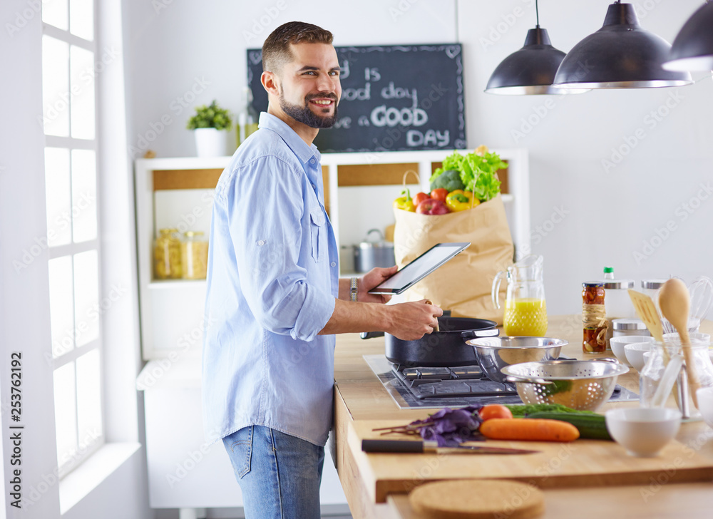 Smiling and confident chef standing in large kitchen Smiling and confident chef standing in large kitchen