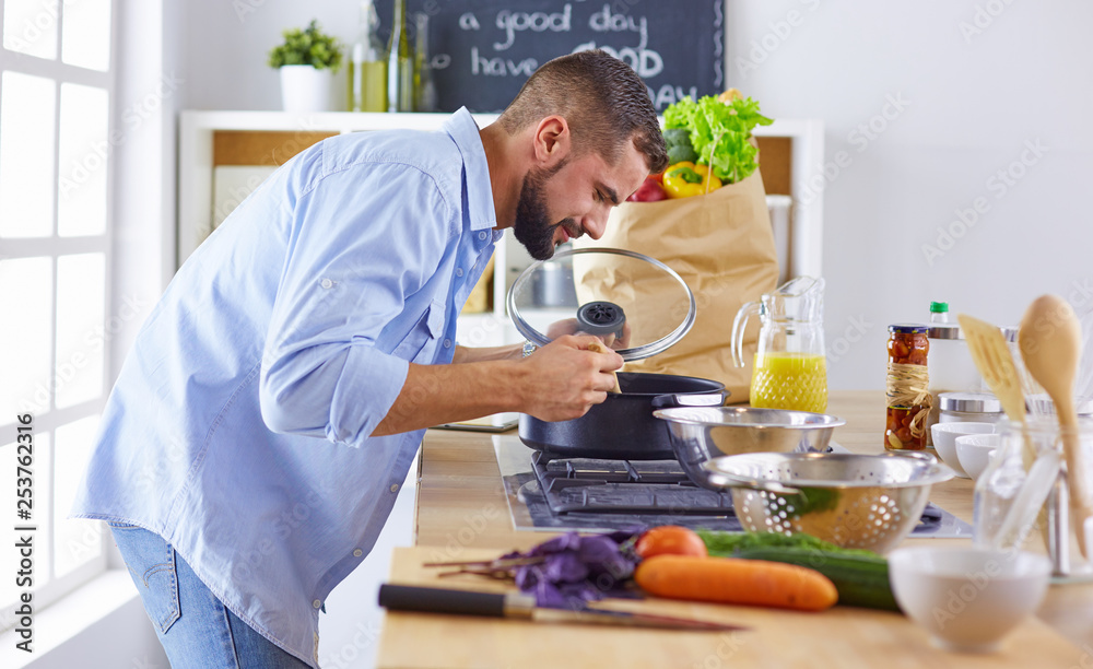 Smiling and confident chef standing in large kitchen Smiling and confident chef standing in large kitchen