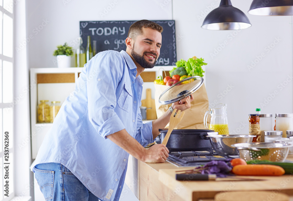 Smiling and confident chef standing in large kitchen Smiling and confident chef standing in large kitchen