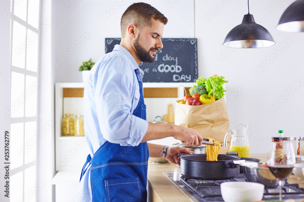 Smiling and confident chef standing in large kitchen Smiling and confident chef standing in large kitchen