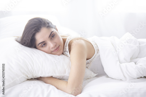 beautiful young woman basking in bed in the morning. Beautiful Model face looks sexy in camera