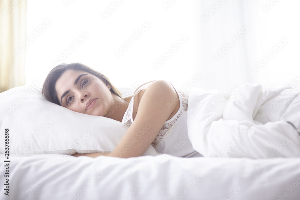 beautiful young woman basking in bed in the morning. Beautiful Model face looks sexy in camera beautiful young woman basking in bed in the morning. Beautiful Model face looks sexy in camera