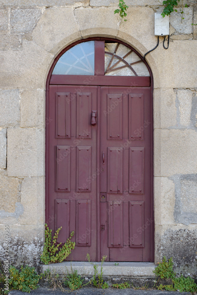 Fototapeta premium antique wooden door in a stone wall