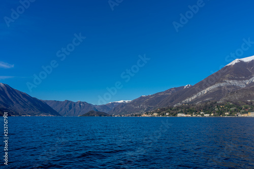 Italy, Bellagio, Lake Como, a large body of water with a mountain in the background © SkandaRamana
