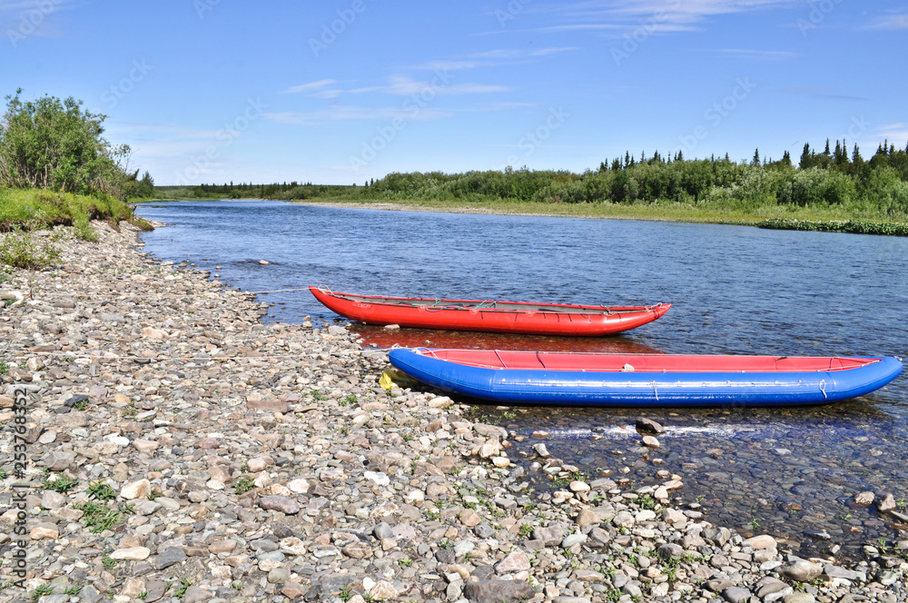 Two inflatable canoes on the shore of North river. Two inflatable canoes on the shore of North river.