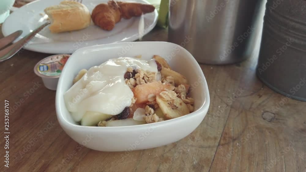 Yogurt pouring on a healthy Granola breakfast Yogurt pouring on a healthy Granola breakfast