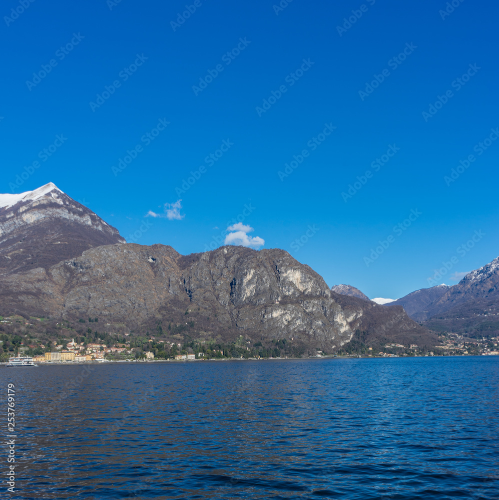 Italy, Bellagio, Lake Como, Cadenabbia, SCENIC VIEW OF SEA AND MOUNTAINS AGAINST CLEAR BLUE SKY