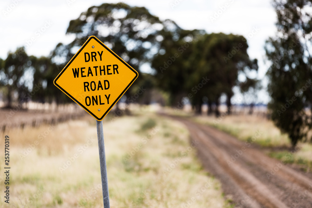 Dry weather only warning sign on a dirt road in rural Australia during drought conditions.