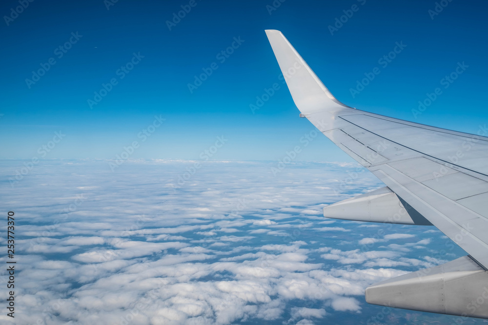 Airplane wing above cloud on the sky ,looking from window of plane Airplane wing above cloud on the sky ,looking from window of plane