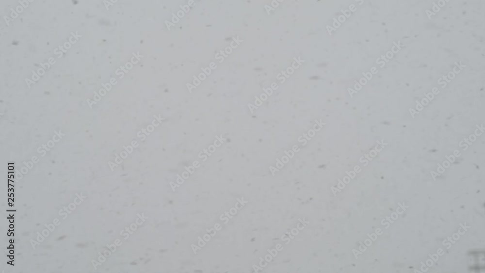 Slow motion of falling snow. Blurred sky in background Slow motion of falling snow. Blurred sky in background