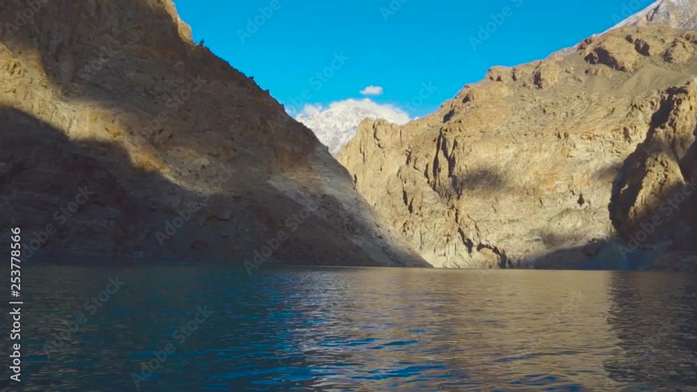 Flowing with peaceful blue lake under the rock stone mountains, Showing ice and blue sky peak of the mountains Flowing with peaceful blue lake under the rock stone mountains, Showing ice and blue sky peak of the mountains