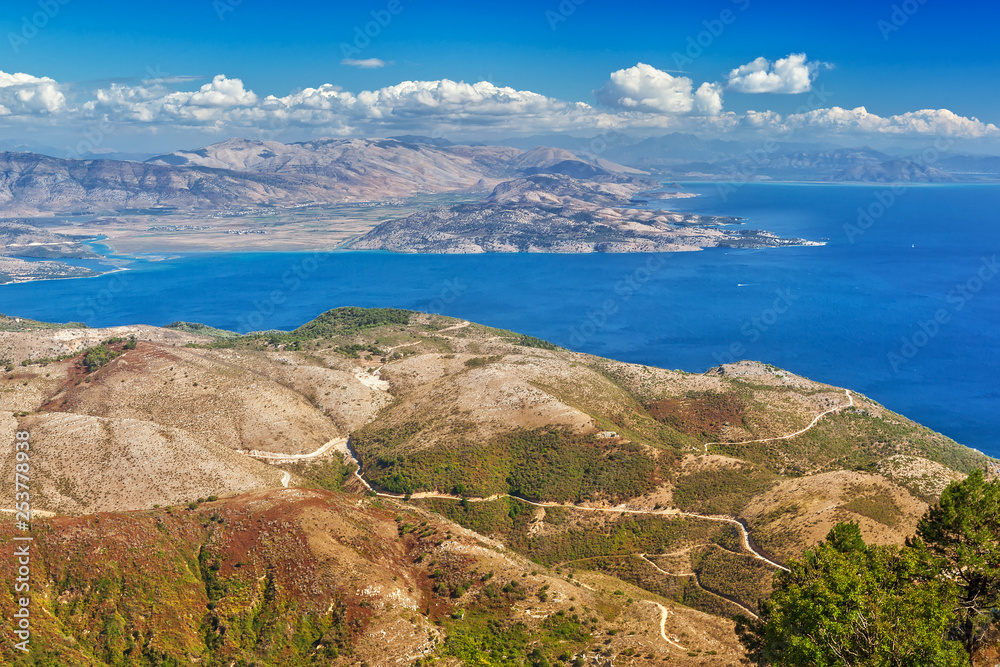 Aerial view over mountains to the rural road and Ionian sea, Pantokrator mountain foothill, Corfu, Greece Aerial view over mountains to the rural road and Ionian sea, Pantokrator mountain foothill, Corfu, Greece