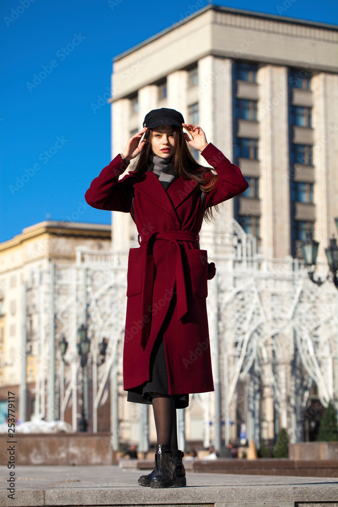 Fototapeta premium Beautiful girl in stylish in a long burgundy coat