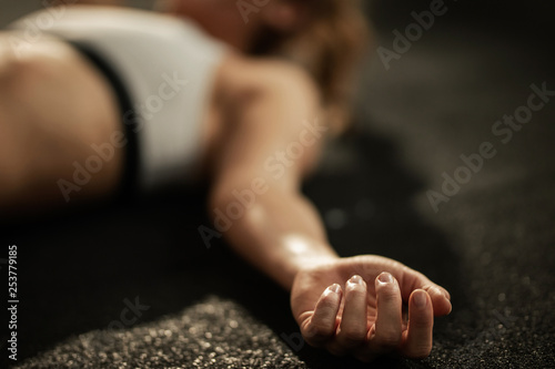 Close up of exhausted athlete resting on the floor after sports training. photo
