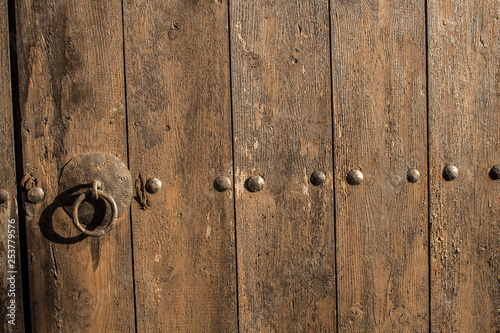 Fotografie Part of old antique wooden gate with rusty metal door ring
